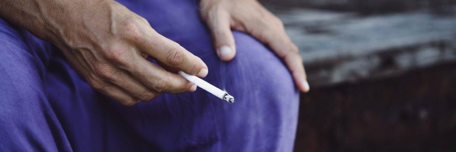 a hand holding cigarette for long term recovery